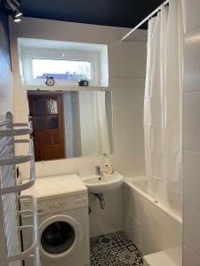 uma casa de banho com uma máquina de lavar roupa e um lavatório em Apartament na Skorupki em Augustów