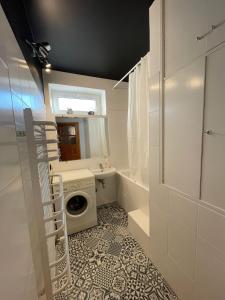 a bathroom with a washing machine and a sink at Apartament na Skorupki in Augustów