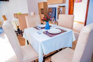 tavolo da pranzo con tovaglia e sedie bianche di NETLUNA VILLA HOTEL a Kigali
