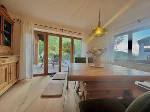 sala de estar con mesa de madera y comedor con vistas. en Ferienhaus "Bodenschneid" am Schliersee en Schliersee