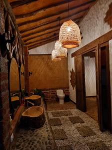a bathroom with a toilet and a chandelier at Cabañas el Nopal in San Gil