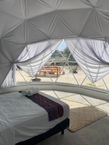 a bed in a tent with a view of a beach at Hidden Island Glamping Isla Mujeres in Isla Mujeres