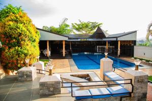 - une piscine avec des chaises longues en face d'une maison dans l'établissement NETLUNA VILLA HOTEL, à Kigali
