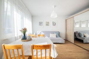 a living room with a table and chairs and a couch at Summer 3 by Grand Apartments in Gdańsk