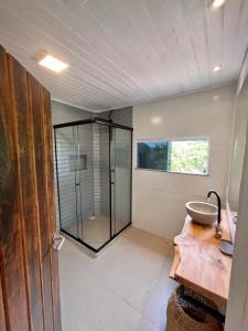 ein Bad mit einem Waschbecken und einer Glasdusche in der Unterkunft Pousada Blanca Inn in Búzios