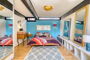 ヴァルヒェンゼーにあるFerien-Chalet-Walchenseeの青い壁のベッドルーム1室、ベッド1台、テーブルが備わります。