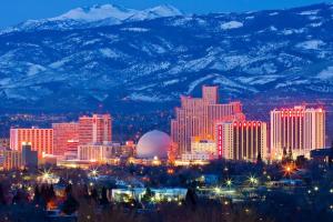 a city skyline at night with snow covered mountains at Reno Studio Gem: Cozy Netflix Free Parking in Reno