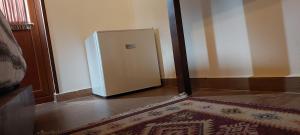 frigorifero in camera con tappeto sul pavimento di KALE GUESTHOUSE a Gjirokastër