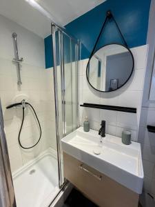 a bathroom with a sink and a shower and a mirror at Cosy nid douillet au cœur du centre ville de Perpignan in Perpignan