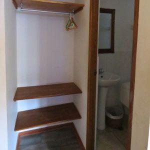 baño con estanterías de madera, lavabo y aseo en hostal Balcon de Piedra, en Urubamba