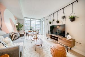 a living room with a couch and a tv at Stylish Downtown Toronto Suite with Free Parking in Toronto