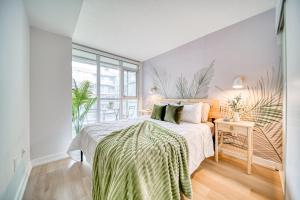 a bedroom with a bed and a large window at Stylish Downtown Toronto Suite with Free Parking in Toronto