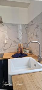 a kitchen with a white sink and a counter at Wellness cottage met hottub 'Auckland' by Kawatea in Ewijk