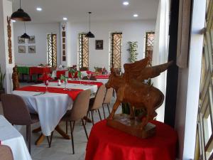 Radama Hotel في أنتاناناريفو: غرفة طعام مع طاولات مع مفارش مائدة حمراء