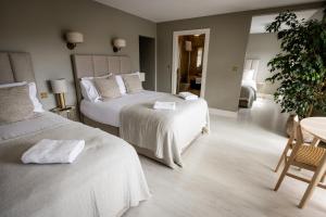 una camera d'albergo con due letti e un tavolo di Coastal View House a Doolin