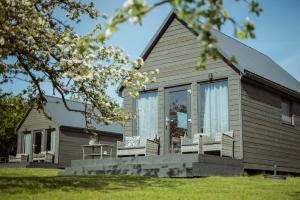 a house with a porch and chairs on it at Vectēva dārzs in Rucava