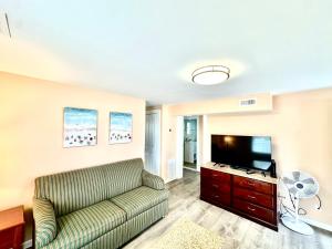 uma sala de estar com um sofá e uma televisão de ecrã plano em Bill's Apartments em Ocean City