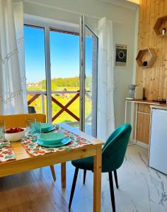 a dining room with a table and a kitchen with a view at Apartamenty Cudne Manowce in Łeba +40 photos