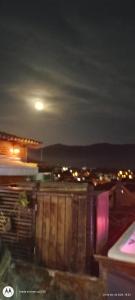 una vista de una ciudad por la noche con la luna en Suíte Verano 1,2,3 e 4 en Niterói