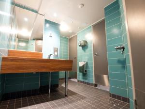 a bathroom with blue tile walls and a sink at Eurohostel in Helsinki