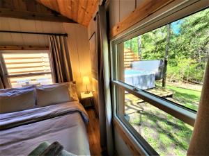 ein Schlafzimmer in einem winzigen Haus mit einem großen Fenster in der Unterkunft Steps to Beach-Hot Tub-Fireplace-Northern Original in Traverse City