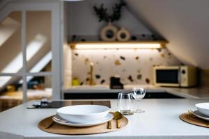 een keuken met een tafel met borden en wijnglazen bij Nook with a view - Quelle in Győr