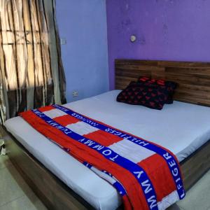 ein Bett mit einer bunten Decke darüber in der Unterkunft Hotel De Pisces in Uyo