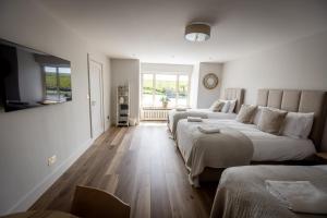 a bedroom with two beds and a large window at Coastal View House in Doolin