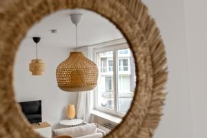a mirror reflecting a living room with a couch and a window at Studio Petite Plage in Ostend