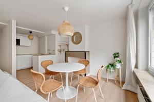 a white dining room with a white table and chairs at Studio Petite Plage in Ostend