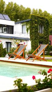 two picnic tables sitting next to a swimming pool at Posada El Capullo in Colonia del Sacramento