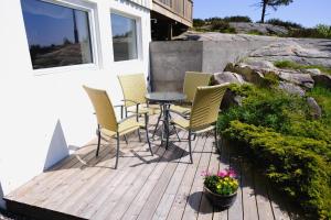 a group of chairs and a table on a deck at Koselig leilighet i Grimstad like ved UiA in Grimstad