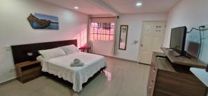 a bedroom with a bed and a flat screen tv at Hostal Marlyn in San Andrés