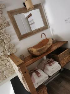 a bathroom with a shelf with towels and a mirror at La petite maison dans les nuages in Tourtour