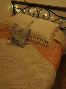 a bed with a blanket and pillows on it at La petite maison dans les nuages in Tourtour