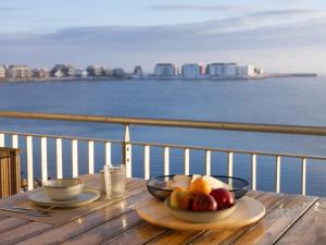 a table with a bowl of fruit on top of a balcony at Hygge Lodge 18 am Strand in Olpenitz