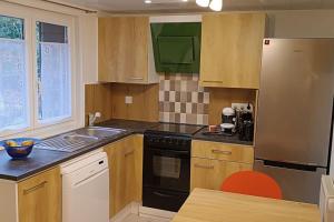 a kitchen with a stove and a sink and a refrigerator at Studio à louer in Clohars-Carnoët