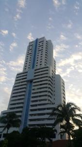 a large white building with palm trees in front of it at PATONGTOWER 3 BEDROOMs 2026 in Patong Beach