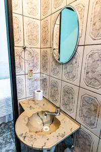 La salle de bains est pourvue d'un lavabo et d'un miroir mural. dans l'établissement Maré Alta Suites - Maresias, à Maresias