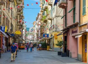 un grupo de personas caminando por una calle con edificios en La Siesta 5 terre, en La Spezia