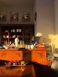 a kitchen with a counter with a bowl of fruit on a table at Epavlis Meteora Suites Hotel in Kalabaka