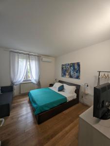 1 dormitorio con 1 cama y TV. en Laspeziaduecentottanta Casa Vacanze 5 TERRE en La Spezia
