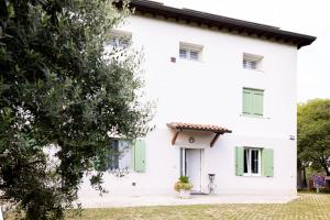 a white house with green windows at Tenuta EnGi in Verona