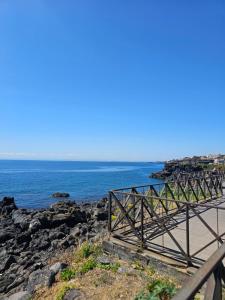 een houten loopbrug naast een strand met de oceaan bij Santrid apartment in Catania