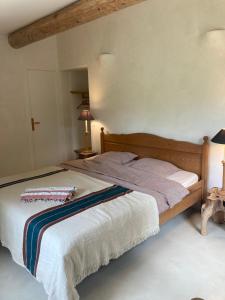 a bedroom with a bed with a wooden headboard at Mas de grange neuve in Mollans-sur-Ouvèze