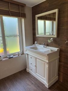 La salle de bains est pourvue d'un lavabo blanc et d'un miroir. dans l'établissement Ars Vivendi, à Strasen