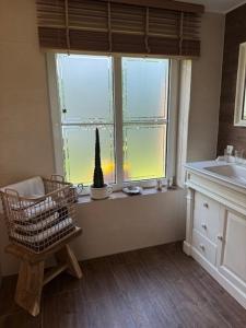 a bathroom with a window with a chair and a sink at Ars Vivendi in Strasen