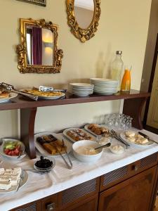 a buffet with plates of food on a table at Epavlis Meteora Suites Hotel in Kalabaka