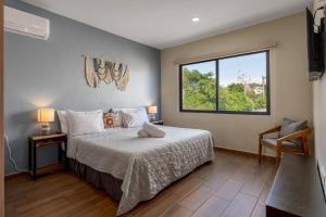 um quarto com uma cama e uma janela em NewComfy~5 Area~Walk 2 Beach~Pool~Views~King Bed em Mazatlán