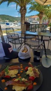 a plate of food on a table with palm trees at PERFECT NEST at Sunset Beach in Vela Luka +58 photos